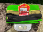 Green saree with a red label on a digital scale showing weight