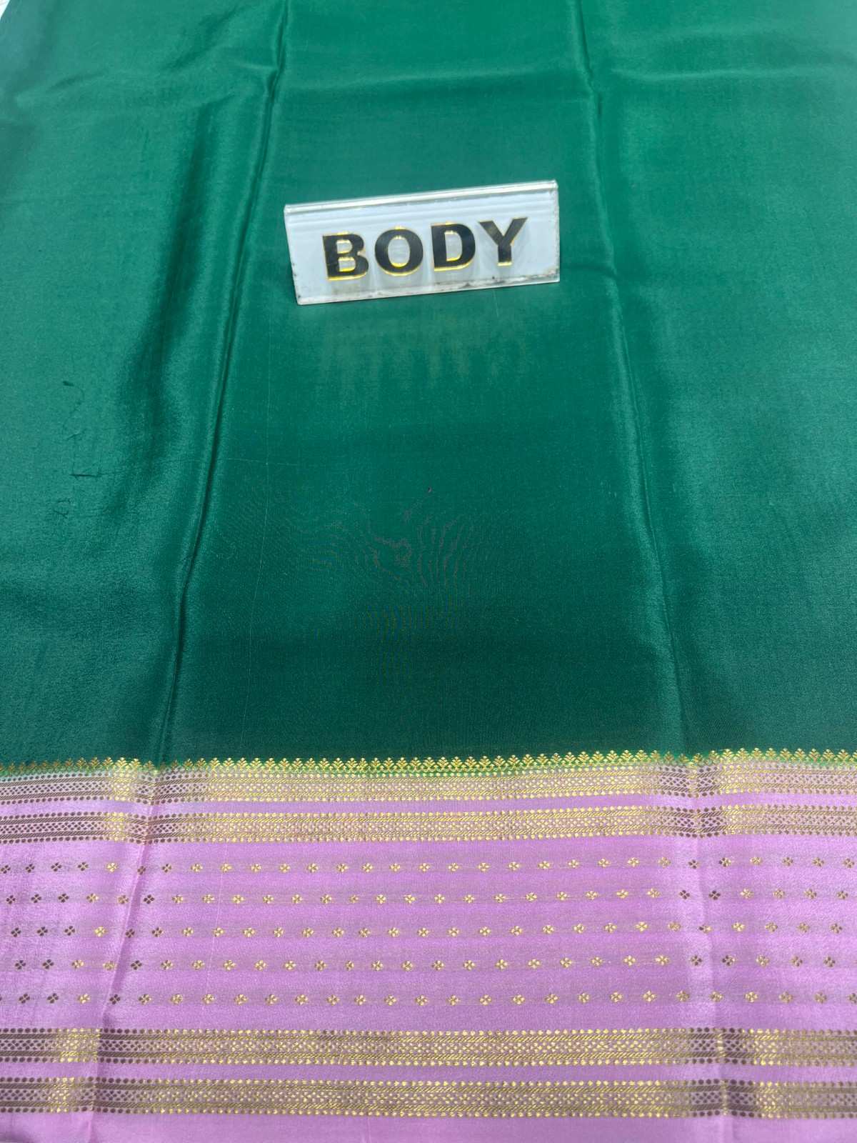 Green fabric with a label labeled 'BODY' and a purple border with gold stripes.