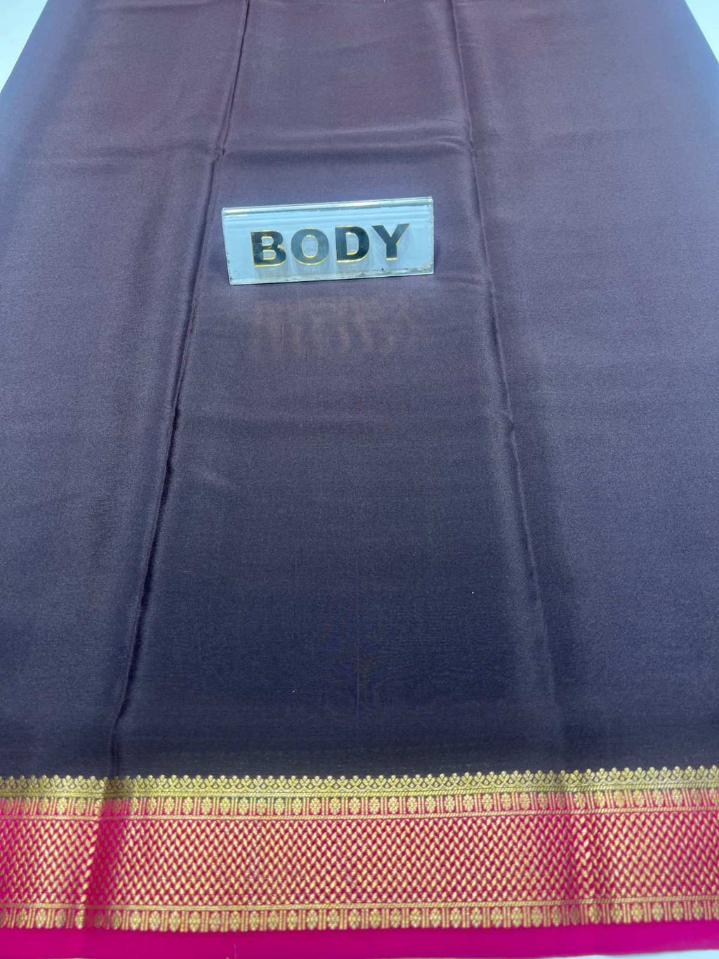 Dark blue saree with gold border and visible 'BODY' label.