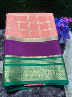 Saree with pink and purple checkered pattern and green border on a dark background