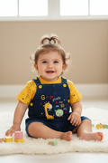 Baby girl wearing giraffe dungaree set