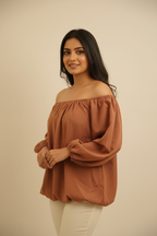 Indian model wearing rust off-shoulder puff sleeve top