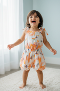 Kid wearing orange abstract print romper