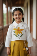 Kid wearing white and mustard yellow floral outfit