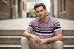 Male model - mauve polo sitting on steps pose