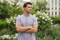 Male model wearing lavender striped polo - arms crossed pose