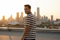 Male model wearing olive striped polo - over shoulder pose