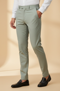 Model in aesthetic pose wearing sage grey-green formal trousers, lower body