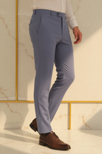 Model in aesthetic pose wearing slate blue formal trousers, lower body