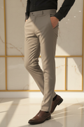 Model in aesthetic pose wearing taupe grey formal trousers, lower body