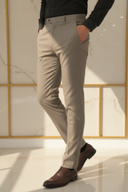 Model in aesthetic pose wearing taupe grey formal trousers, lower body