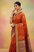Model wearing burnt orange Kanchipuram silk saree with wine purple peacock border