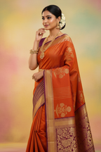Model wearing burnt orange Kanchipuram silk saree with wine purple peacock border