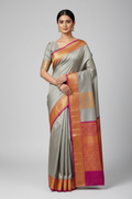 Model wearing silver-grey Banarasi saree with magenta orange gold border
