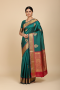 Model wearing teal Banarasi saree with red gold zari border