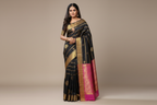 Woman wearing black saree with gold stripe bands and magenta pink zari border