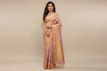 Woman wearing dusty rose pink saree with gold peacock motifs