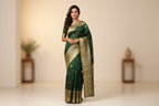 Woman wearing forest green silk saree with cream beige gold zari border