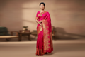 Woman wearing hot pink fuchsia saree with red gold peacock zari border