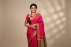 Woman wearing hot pink silk saree with black gold zari geometric border