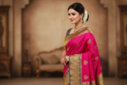 Woman wearing magenta pink saree with grey gold zari border